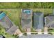 Top-down view of backyard featuring a screened pool, a lush lawn, and the roof and driveways of neighboring properties at 14384 Alafaya Oak Bnd, Orlando, FL 32828