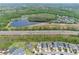 Aerial view of the home in relation to the neighborhood, nearby lake, road, and landscaping at 14384 Alafaya Oak Bnd, Orlando, FL 32828