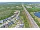 Aerial view of homes in a community with a pool and a highway nearby, surrounded by natural areas at 14384 Alafaya Oak Bnd, Orlando, FL 32828