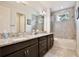 Bathroom features double sinks, granite counters, and a shower over tub with tiled surround at 14384 Alafaya Oak Bnd, Orlando, FL 32828