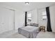 Bedroom with carpeted floors, gray blackout curtains, standard closet, and two windows at 14384 Alafaya Oak Bnd, Orlando, FL 32828