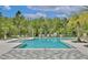 Community pool surrounded by lounge chairs and beautiful landscaping at 14384 Alafaya Oak Bnd, Orlando, FL 32828