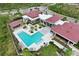Aerial view of a community pool with lounge chairs and a red-roofed building surrounded by lush landscaping at 14384 Alafaya Oak Bnd, Orlando, FL 32828
