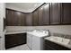 Laundry room with dark cabinets, sink, granite counters, washer, and dryer at 14384 Alafaya Oak Bnd, Orlando, FL 32828