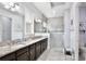 Primary bathroom featuring double sinks, granite countertops, and a glass enclosed shower at 14384 Alafaya Oak Bnd, Orlando, FL 32828