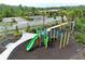 Overhead view of a green and yellow playground with a bench and mature landscaping at 14384 Alafaya Oak Bnd, Orlando, FL 32828