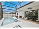 Screened-in pool with outdoor seating and dining area on a bright, sunny day at 14384 Alafaya Oak Bnd, Orlando, FL 32828