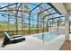 Screened in pool area with lounge chairs and plenty of tall trees providing backyard privacy at 14384 Alafaya Oak Bnd, Orlando, FL 32828