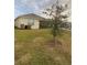 Side view of a backyard featuring a well-maintained lawn and exterior of the house at 1548 Planters Point Rd, Kissimmee, FL 34744