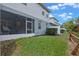 View of the backyard showing the screened patio, grassy area, and a wooden fence at 1562 Travertine Ter, Sanford, FL 32771