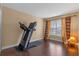 Well-lit bedroom with a treadmill, hardwood floors, and neutral walls at 1562 Travertine Ter, Sanford, FL 32771