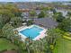 A beautiful aerial view of the community pool area featuring a pool, chairs, and tropical landscaping at 1562 Travertine Ter, Sanford, FL 32771