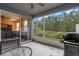 View of the screened patio with a table, grill, and sliding glass doors opening to the home's interior at 1562 Travertine Ter, Sanford, FL 32771
