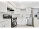 Modern kitchen featuring stainless steel appliances, white cabinetry, and a bright, airy design at 1612 Idaho Ave, Belle Isle, FL 32809