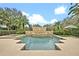 Beautiful pool with fountains and a spa, surrounded by lush landscaping and blue skies at 1627 Elizabeths Walk, Winter Park, FL 32789