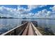 Picturesque lake view with a wooden pier and calm waters surrounded by lush greenery at 16328 Rock Coast Dr, Winter Garden, FL 34787