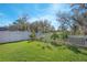 Expansive backyard featuring a well-manicured lawn, mature trees, and a charming white picket fence at 1636 Barberry Dr, Kissimmee, FL 34744