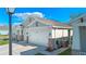 Exterior view of a two-car garage with stone accents and a well-maintained yard under a bright blue sky at 1636 Barberry Dr, Kissimmee, FL 34744