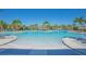 Large community pool with clear water surrounded by lounge chairs and palm trees, perfect for a refreshing swim at 1636 Barberry Dr, Kissimmee, FL 34744