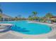 Large community pool surrounded by lounge chairs, tropical palm trees, and shaded seating areas for leisure at 1636 Barberry Dr, Kissimmee, FL 34744