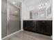 Modern bathroom with dual sinks, dark wood cabinetry, and a glass-enclosed shower for a spa-like experience at 1760 Astrid Rd, Davenport, FL 33837