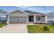Charming single-story home featuring a two-car garage, manicured lawn, and inviting front entry at 1760 Astrid Rd, Davenport, FL 33837