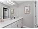 Bathroom featuring single sink vanity with white cabinets, decorative mirror, and artwork at 1795 Nw 44Th Ct Rd, Ocala, FL 34482
