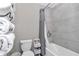 Compact bathroom featuring a tub and shower combo with tiled walls, toilet and a storage rack at 1795 Nw 44Th Ct Rd, Ocala, FL 34482
