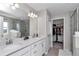 Modern bathroom featuring double vanity with quartz countertop, large mirror, and walk-in closet at 1795 Nw 44Th Ct Rd, Ocala, FL 34482