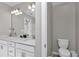 Bathroom featuring double sink vanity with white cabinets, decorative mirror, and separate toilet room at 1795 Nw 44Th Ct Rd, Ocala, FL 34482