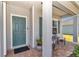 A covered front porch offers a cozy spot, complete with seating, brick floors, and a blue door at 1795 Nw 44Th Ct Rd, Ocala, FL 34482
