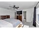 Bright main bedroom with wood furnishings, ceiling fan, TV, and ensuite bathroom access at 1795 Nw 44Th Ct Rd, Ocala, FL 34482
