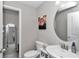 A cozy powder room features a pedestal sink, round mirror, and tiled floors at 1795 Nw 44Th Ct Rd, Ocala, FL 34482