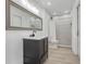 Modern bathroom featuring a sleek vanity, framed mirror, and tiled shower with neutral tones at 1838 Warringwood Dr # B-3, Orlando, FL 32839