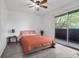 Bright bedroom with a ceiling fan and sliding glass door to private balcony at 1838 Warringwood Dr # B-3, Orlando, FL 32839