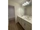 Bathroom with double sink vanity, large mirror, and tub in a well-lit and modern space at 2202 Bass Catcher Dr, Davenport, FL 33837