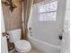 Bright bathroom featuring a white bathtub with shower curtain and a mosaic-patterned window at 2368 Buckingham Run Ct, Orlando, FL 32828
