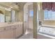 Bright bathroom featuring a walk-in shower, and a large soaking tub with jacuzzi jets at 2368 Buckingham Run Ct, Orlando, FL 32828
