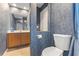 Bathroom with vanity, blue wallpaper and a nearby toilet, and a door with shower access at 2368 Buckingham Run Ct, Orlando, FL 32828