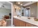 Bathroom with double sink vanity, and an open doorway to bedroom with floral bedding and a ceiling fan at 2368 Buckingham Run Ct, Orlando, FL 32828