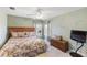 Cozy bedroom with a floral comforter, ceiling fan, and light green walls with leaf details at 2368 Buckingham Run Ct, Orlando, FL 32828