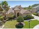 Beautiful home with a well-manicured lawn, mature palm trees, and a tile roof, creating an inviting curb appeal at 2368 Buckingham Run Ct, Orlando, FL 32828