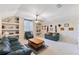 A spacious, carpeted living room with built-in shelving, comfortable seating, and a ceiling fan at 2368 Buckingham Run Ct, Orlando, FL 32828