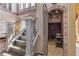 Grand staircase with wrought iron railing leading to an ornate wine cellar with brick accents and arched doorway at 2368 Buckingham Run Ct, Orlando, FL 32828
