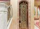 Ornate wine cellar with decorative metal gate, brick trim, and space for wine storage at 2368 Buckingham Run Ct, Orlando, FL 32828