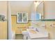 Bathroom featuring a bathtub and shower, a window, and bright yellow tile at 2613 Nela Ave, Belle Isle, FL 32809