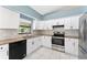 Modern kitchen featuring white cabinets, stainless steel appliances, and granite countertops at 2665 Windsor Heights St, Deltona, FL 32738