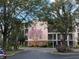 Multi-story building with a pink tree, landscaping and balconies on each unit at 3050 Pirates Retreat Ct # 402, Kissimmee, FL 34747