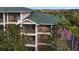 Condo's exterior boasts screened balconies on multiple floors, offering private outdoor spaces with treetop views at 3050 Pirates Retreat Ct # 402, Kissimmee, FL 34747