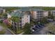Wide exterior view of the condo building with multiple units, parking area, and surrounding landscaping at 3050 Pirates Retreat Ct # 402, Kissimmee, FL 34747